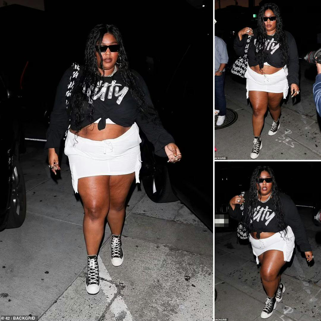 Cover Image for Lizzo confidently shows off her curves in a black Yitty top and white miniskirt as she enjoys a night out in West Hollywood.